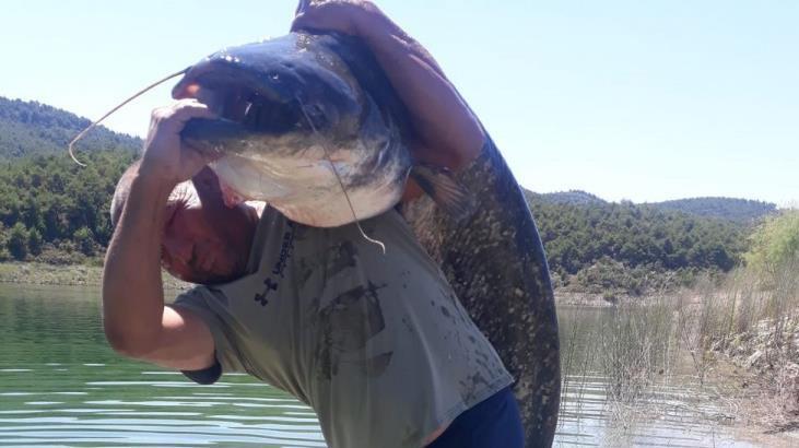 Gölde yakaladığı dev yayın balığını sırtında zor taşıdı